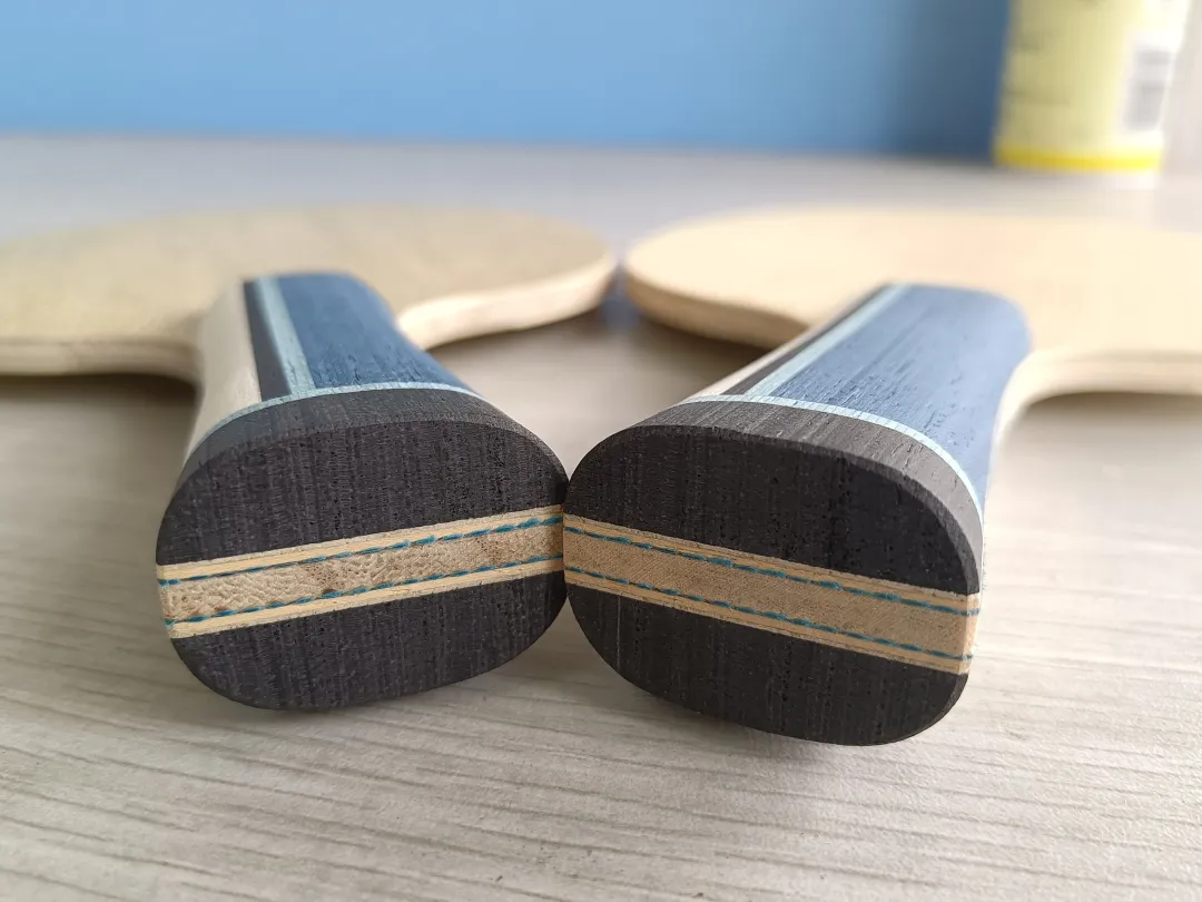 Close-up of two blade edges showing the ply structure and core thickness